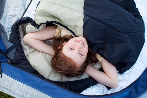 High angle portrait of cute little girl lying in tent